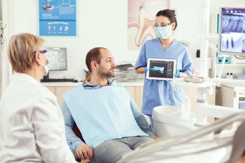 A person admiring their bright, white smile in a mirror after a successful teeth whitening treatment Poole